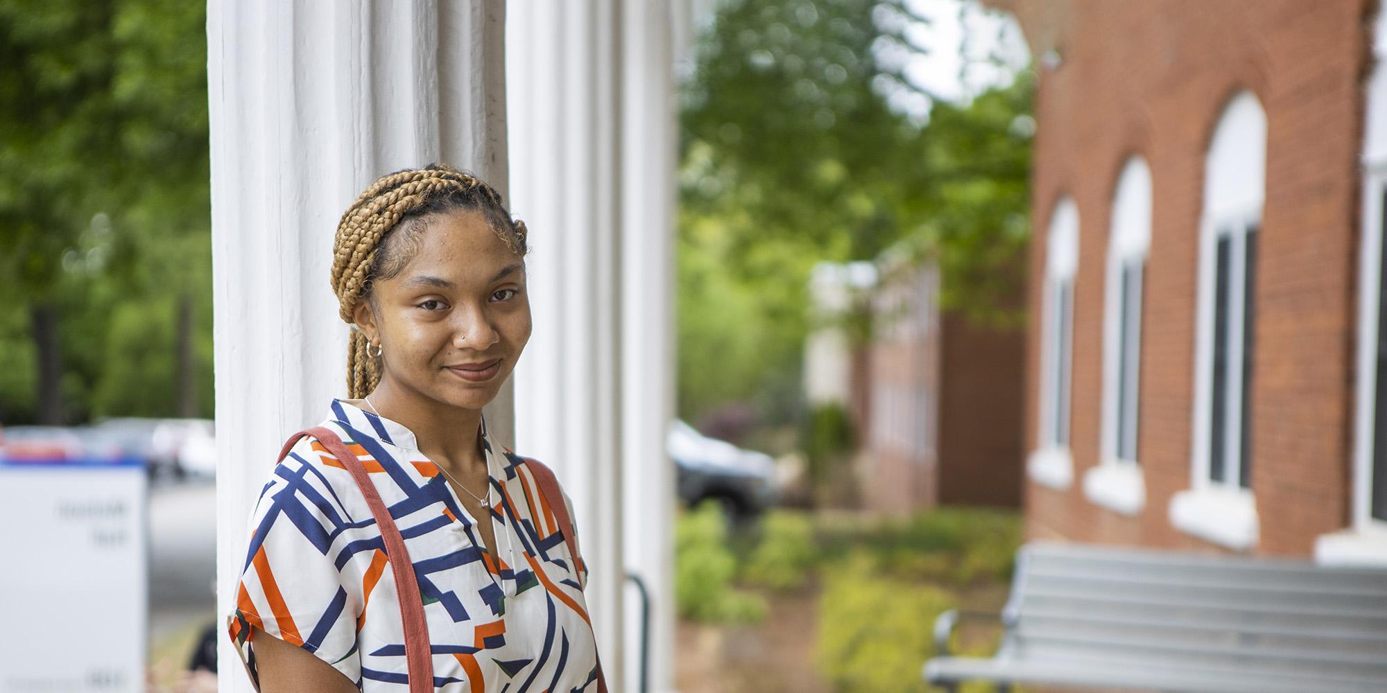 student outside of Melson Hall